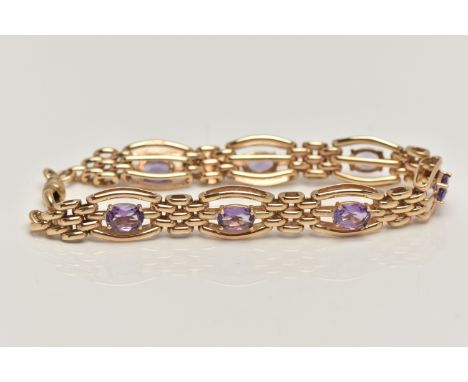 A 9CT GOLD AMETHYST BRACELET, seven oval cut amethyst prong set in yellow gold, interspaced between brick links, fitted with 