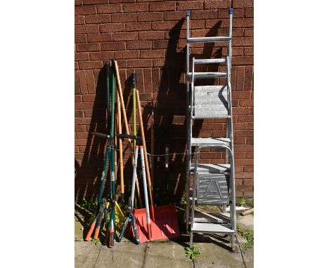 A SELECTION OF GARDEN TOOLS, to include rakes, shovels, pitch forks, etc, and three sized step ladders, largest height 193cm