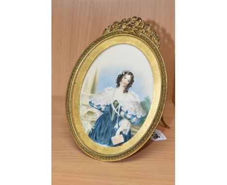 A LATE VICTORIAN PORTRAIT MINIATURE, depicting a female figure holding a book, unsigned, watercolour on paper in gilt metal e
