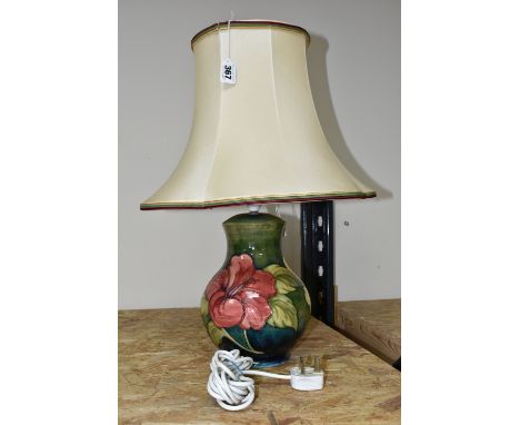 A MOORCROFT POTTERY 'HIBISCUS' TABLE LAMP, decorated with red and yellow Hibiscus on a green ground, with a cream shade, heig