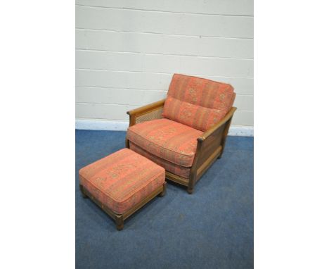 AN ERCOL ELM AND BEGERE ARMCHAIR, with floral fabric, and a matching footstool (condition report: good)