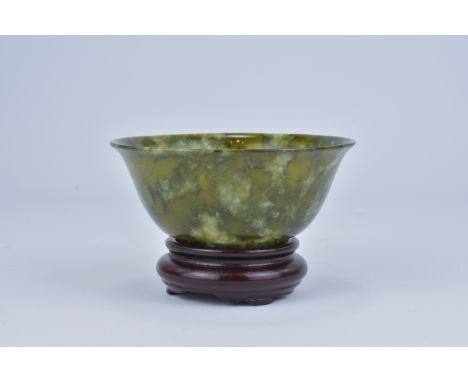 A Chinese Spinach Jade colour Bowenite serpentine Bowl 20th Century with wooden stand.