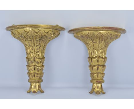 A pair of ornate gilt wooden wall shelf brackets.