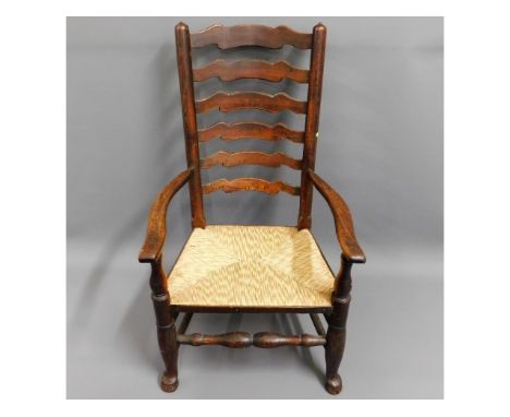 An 18thC. ladder back chair with rush seat, 41.25in high to back