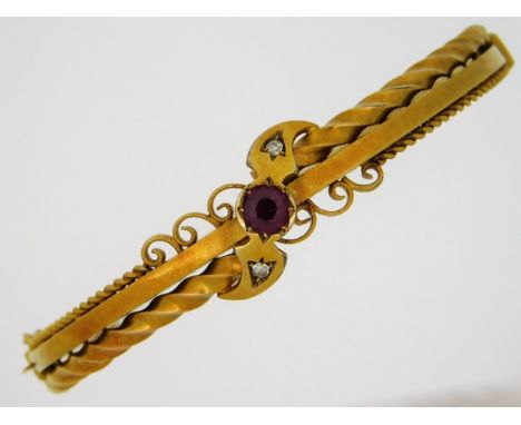 An Edwardian 15ct gold bangle set with approx. 0.65ct ruby &amp; two small diamonds. 54mm internal diameter, 9.28g