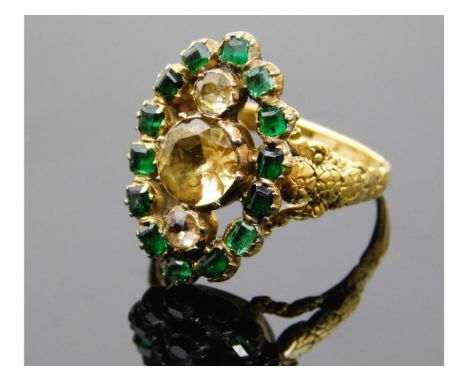 A yellow metal 19thC. emerald &amp; yellow topaz ring with carved decor &amp; closed back stones, electronically tests as at 