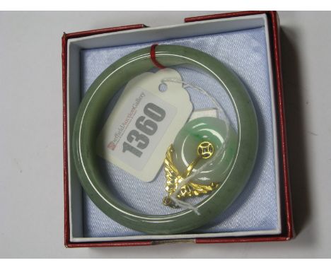 An Eastern Jade Pendant, with pierced surmount; together with a Chinese Jade bangle (boxed). (2)