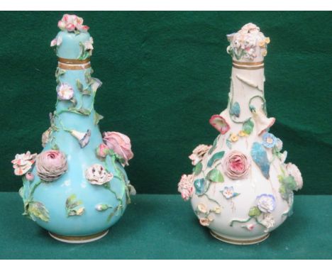 PAIR OF CONTINENTAL STYLE RELIEF FLORAL DECORATED CERAMIC VASES WITH COVERS, APPROXIMATELY 28cm HIGH (AT FAULT)