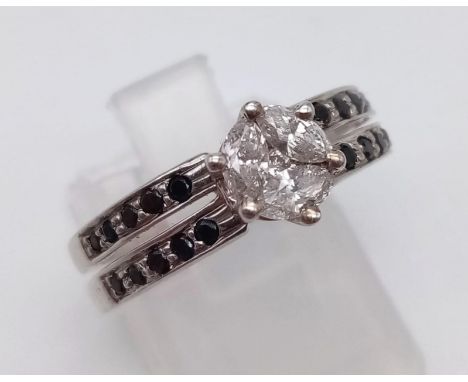 A 9K White Gold Black and White Diamond Ring. Central white diamond with black diamonds on shoulders. 0.45ct. Size M. 3g. 