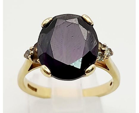 A Vintage 9K Yellow Gold Amethyst Ring. Dark faceted oval amethyst on a crown setting with small diamonds on shoulders. Size 