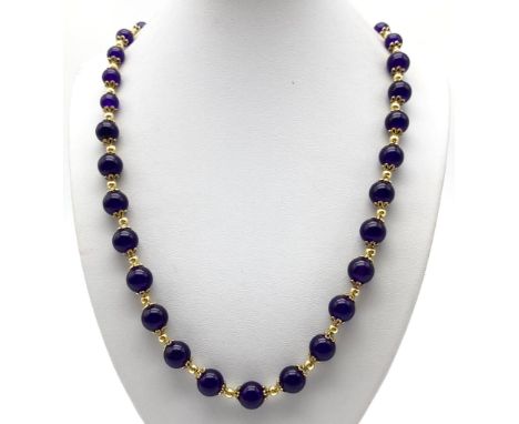 A Graduated Purple Jade Beaded Necklace - With gilded spacers and clasp. 48cm. 
