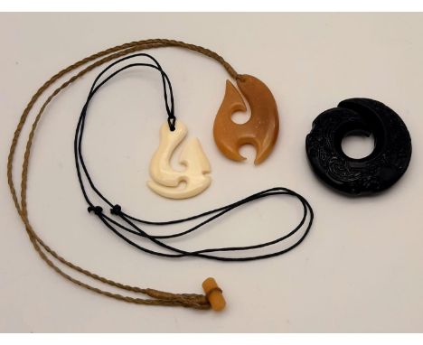 Three M?ori/Polynesian amulets (in the form of stylised fishing hook). One is made of black jade (48 mm), one ofhorn (47 mm) 