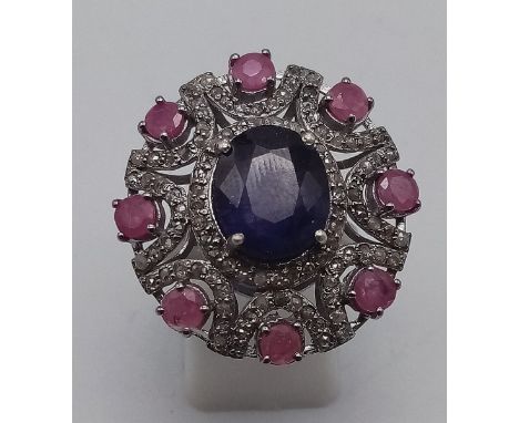 A very impressive 8cts Blue Sapphire centre stone Ring with 2cts Ruby Accents and 1.10cts Diamonds in Pave Setting decoration