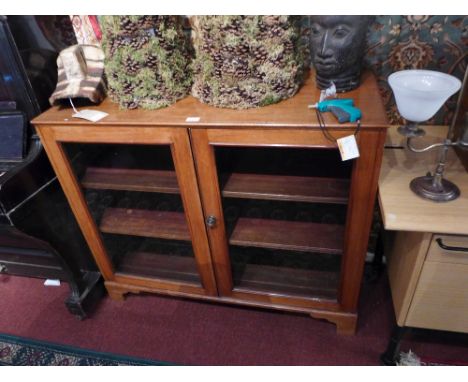 A 19th Century mahogany draftsman's cabinet with two glazed doors enclosing two adjustable shelves and raised on carved brack