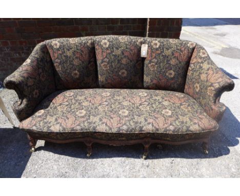 A mid - Victorian shell back sofa, upholstered in floral Liberty fabric raised on carved walnut front rail and cabriole suppo