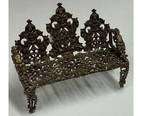 An Antique silver gilt toy bench with pierced and figural decoration. Approx. 28 grams. Est. £50 - £80.