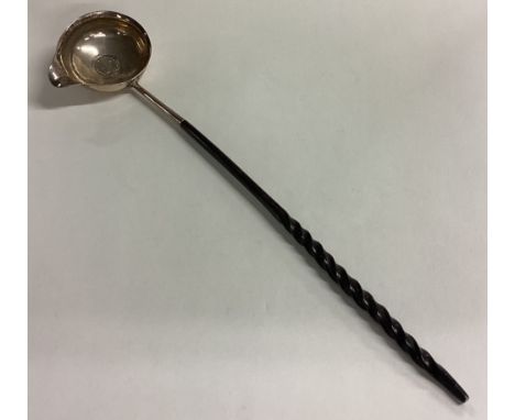 A good Georgian silver toddy ladle with pouring lip and whalebone handle. Approx. 34 grams. Est. £30 - £40.