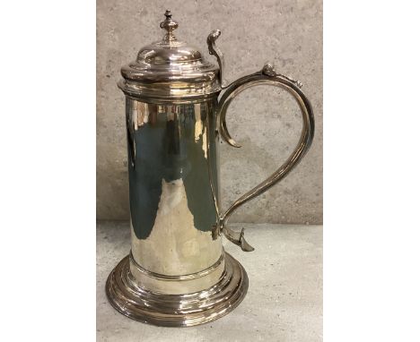 A large George II silver flagon of plain cylindrical form, the domed hinged lid with knopped finial and scroll thumb-piece, t