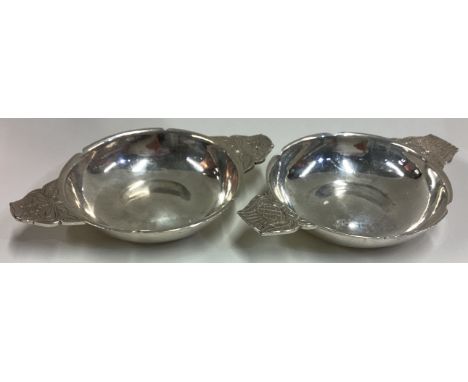 R E STONE: A pair of silver wine tasters engraved with floral decoration to handle in the early Charles II style. London. Cir