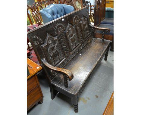 A dark oak hall bench with carved back panels, 134cm wide