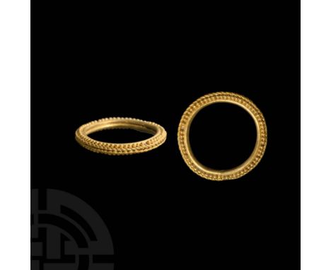 6th-5th century BC. A gold ring composed of a D-section annular hoop ornamented with a medial band of plaited gold wire, a si