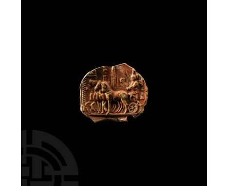 4th century AD. A clay lamp fragment with red slip, depicting a victorious quadriga in a hippodrome, the Auriga standing on t