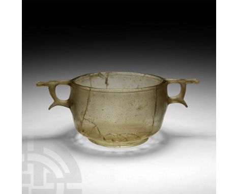 1st century BC-1st century AD. A clear glass skyphos with vertical body walls, tapering towards the rim, splayed circular foo