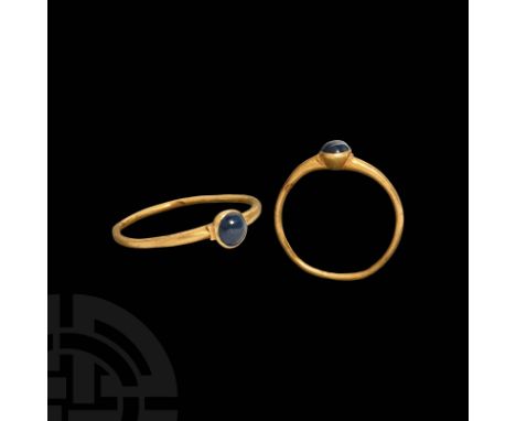 13th-14th century AD. A gold ring formed with round-section band and projecting cup bezel with a circular sapphire set en cab