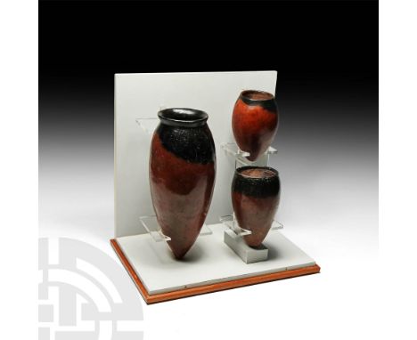 Naqada I-II Periods, c.3900-3200 BC. A group of three black-topped pottery vessels of varied size; the larger ovoid jar with 