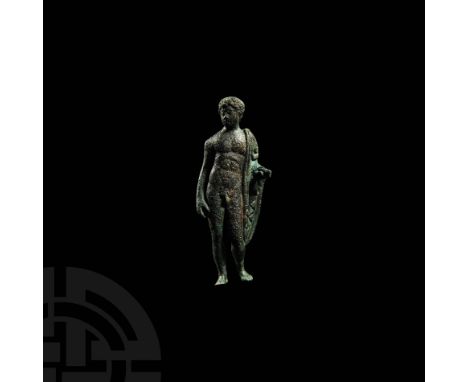 1st-2nd century AD. A bronze figure of Apollo standing nude with hair cut in the Julian style, toga draped over the left shou
