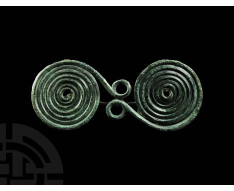 11th-8th century BC. A bronze spectacle brooch of Type I, formed as a single length of round-section wire with a pair of smal