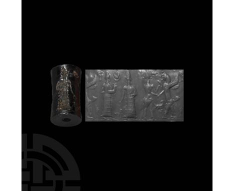 2nd millennium BC. A waisted cylindrical black stone cylinder seal, bearing intaglio frieze composed of a standing human figu