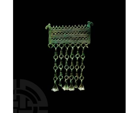 10th-12th century AD. A bronze pendant with openwork rectangular body and stylised horse head terminals, comprising horizonta