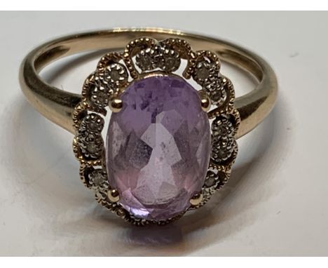 A 9 CARAT GOLD RING WITH A LARGE AMETHYST STONE SURROUNDED BY DIAMONDS SIZE U IN A PRESENTATION BOX 