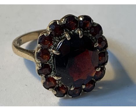 A 9 CATAT GOLD RING WITH FIFTEEN GARNETS IN A FLOWER DESIGN SIZE P/Q GROSS WEIGHT 5.45 GRAMS 