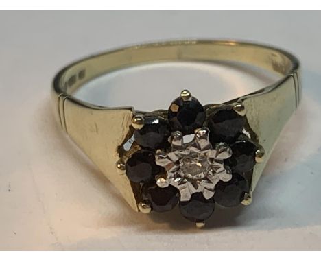 A 9 CARAT GOLD RING WITH A CENTRE DIAMOND SURROUNDED BY SAPPHIRES SIZE P/Q 