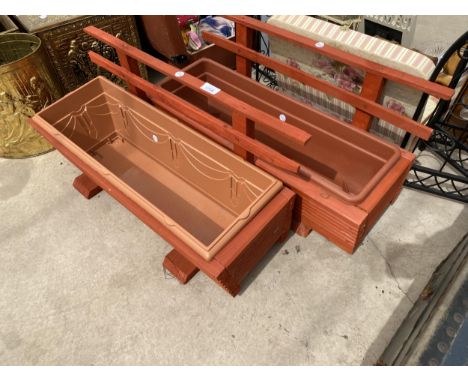 A PAIR OF WOODEN TROUGH PLANTERS WITH PLASTIC INSERTS AND TRELIS BACKS 