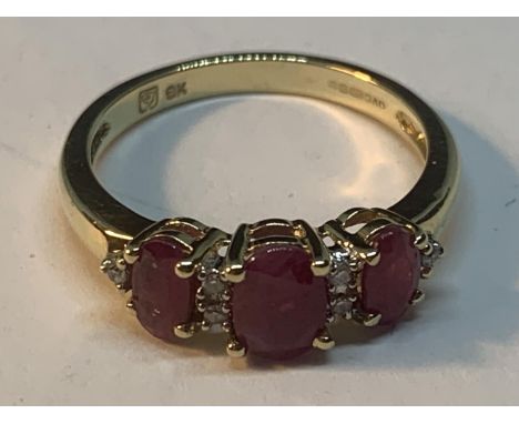 A 9 CARAT GOLD RING WITH THREE RUBIES AND DIAMONDS IN BETWEEN SIZE K 