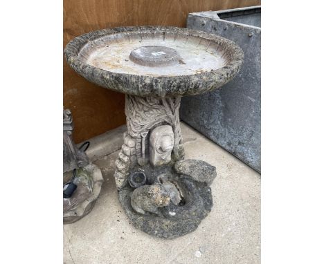 A RECONSTITUTED STONE BIRDBATH WITH PEDESTAL BASE FEATURING ANIMALS AT A TROUGH 