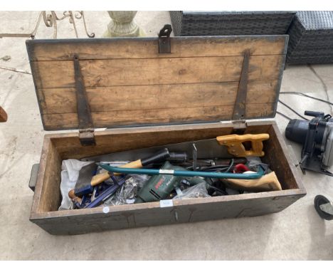 A VINTAGE WOODEN TOOL CHEST CONTAINING AN ASSORTMENT OF TOOLS TO INCLUDE A WOOD PLANE AND AN AXE ETC 
