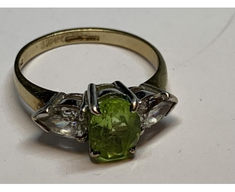 A 9 CARAT GOLD RING WITH A CENTRE PERIDOT AND CUBIC ZIRCONIA ON THE SHOULDERS SIZE L/M 