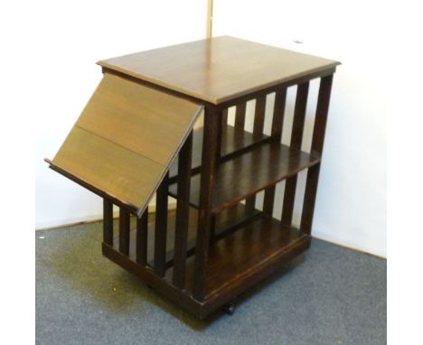 A 1920s oak revolving bookcase, with fold out shelf, 56cm x 68cm x 90cm high