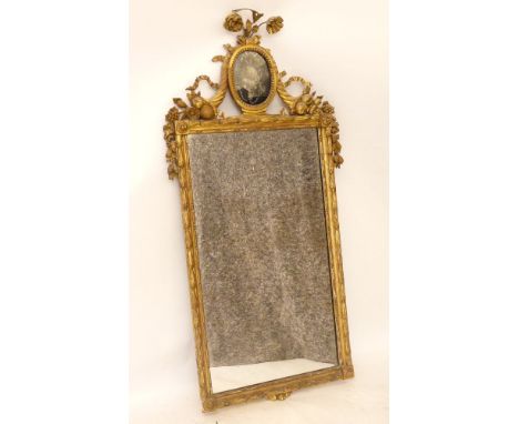 A Continental gilt wood and gesso mirror, central painted glass panel, decorated and surrounded with scrolling fruits