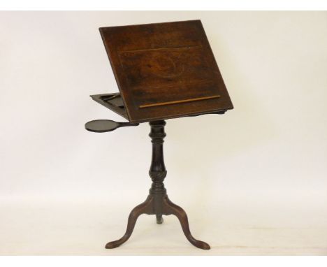 A George III mahogany reading table, with a ratchet top and two candle slides, on a tripod stand