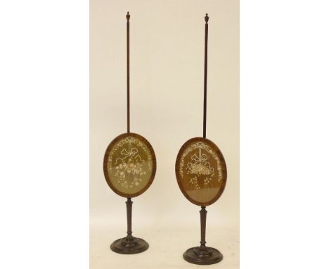A pair of Regency mahogany pole screens, each panel silk embroidered with baskets of flowers, 137cm high