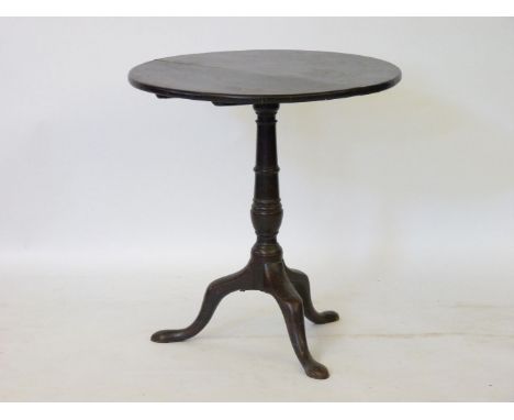 A George III oak tilt top tripod table, the circular top above a turned baluster on cabriole legs, 68cm diameter