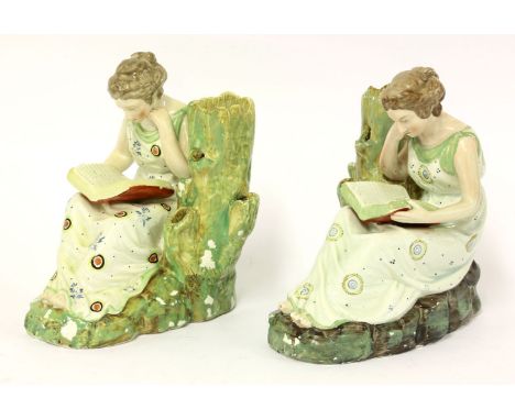 A pair of Staffordshire pearlware figures of literature, circa 1800, each as a girl seated by a spill holder stump reading a 