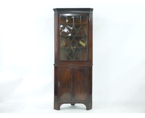 A Georgian mahogany freestanding corner cupboard, and a George III carved bedpost lamp