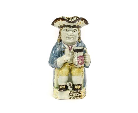 A Yorkshire Prattware Toby Jug, circa 1810, of traditional form with caryatid handle, the seated figure holding a beaker and 