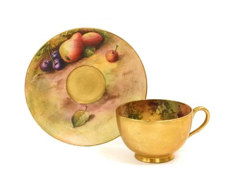 A Royal Worcester Porcelain Cup and Saucer, by George Moseley, 1930, painted with still lifes of fruit on a mossy ground, sig